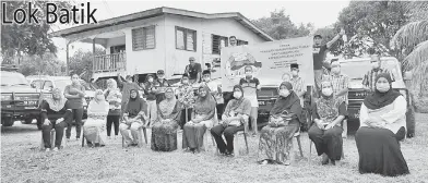  ??  ?? KENANGAN: Sukarelawa­n bergambar kenangan bersama penerima sumbangan.