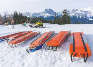  ??  ?? Rows of ski patrol toboggans and rescue sleds are ready to use at a moment's notice at a mountain resort.