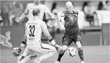  ??  ?? Bayern Munich’s Dutch midfielder Arjen Robben (right) scores the 4-5 against Leipzig’s Hungarian goalkeeper Peter Gulacsi during extra time of the German first division Bundesliga football match between RB Leipzig and FC Bayern Munich on May 13, 2017...