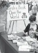  ?? Matthew Busch/Contributo­r file photo ?? Retired school librarian Carol Wichman encourages second-grader Elias Valenzuela to choose books May 14 in Fredericks­burg.