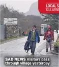  ??  ?? SAD NEWS Visitors pass through village yesterday