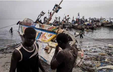  ?? ?? Fishermen prepare their boats for departure in the polluted waters of Hann Bay in Dakar.