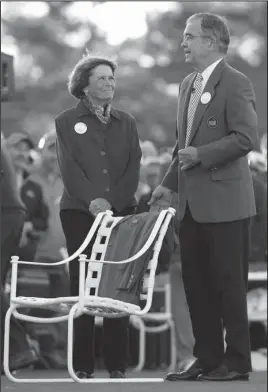  ?? The Associated Press ?? LONG LIVE THE KING: Billy Payne, chairman of Augusta National Golf Club, with Kathleen “Kit” Gawthrop, widow of Arnold Palmer, places a green jacket on a chair to honor the four-time Masters champion before the first round at Augusta National Golf Club...