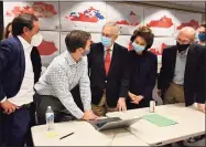  ?? Timothy D. Easley / Associated Press ?? U.S. Sen. Mitch McConnell, center, talks with a staff members as they watch the results of his reelection campaign on a laptop in Louisville, Ky., on Tuesday. McConnell’s wife, Elaine Chao, stands next to him.