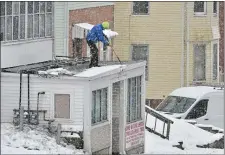  ?? CHRIS CHRISTO — BOSTON HERALD ?? A person clears ice and snow from a roof on Belmont Street in Worcester.