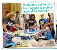  ??  ?? Volunteers put items into baggies to protect against the weather