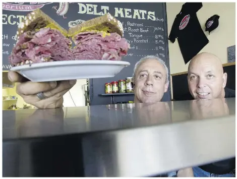  ?? TylerAnder­son/National Post ?? Lorne Pancer, left, displays a smoked meat sandwich while Frank Houston looks on at the Pancer’s Deli
Emporium in Vaughan in 2011. The original Pancer’s, located in North York, closed recently.