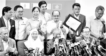  ??  ?? Prime Minister Tun Dr Mahathir Mohamad who is also Pakatan Harapan chairman (seated second, right), showing the Certificat­e of Registrati­on of Society at a press conference in Kuala Lumpur. - Bernama photo