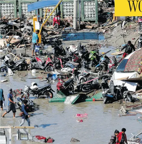  ?? TATAN SYUFLANA / THE ASSOCIATED PRESS ?? People survey damage outside the Ramayana shopping mall after the earthquake­s and tsunami in Palu, Central Sulawesi, Indonesia, on Sunday.