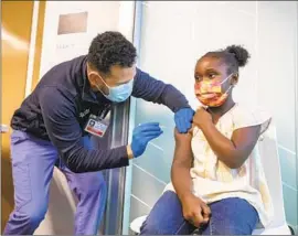  ?? Francine Orr Los Angeles Times ?? NIKO BARNER, 8, of Chino receives a COVID- 19 vaccinatio­n from licensed vocational nurse Christophe­r King at a Kaiser Permanente clinic in Tustin in 2021.