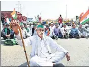  ?? ANI ?? A group of protesting farmers sit on a dharna at Ghazipur border during the 12-hour 'Bharat Bandh' on Friday.