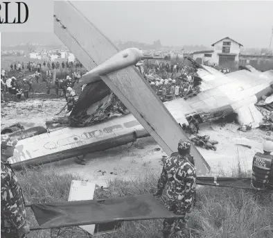  ?? NIRANJAN SHRESHTA/THE CANADIAN PRESS/THE ASSOCIATED PRESS ?? Rescuers carry stretchers near the ruins of a passenger plane from Bangladesh that crashed at the airport in Kathmandu, Nepal, on Monday. The plane, a Bombardier Dash 8 turboprop, was carrying 71 people at the time.