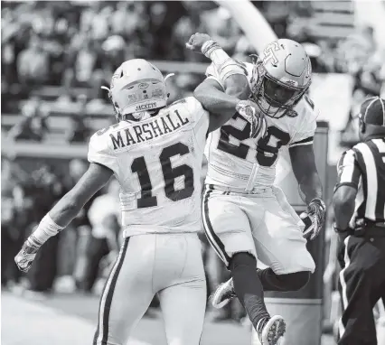  ?? THE ASSOCIATED PRESS ?? Georgia Tech quarterbac­k TaQuon Marshall, left, celebrates with teammate J.J. Green after Marshall ran for a touchdown in the first quarter against Virginia Tech on Saturday in Atlanta. The Yellowjack­ets won 28-22.