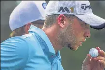  ?? YALONDA M. JAMES / THE COMMERCIAL APPEAL ?? Daniel Berger blows on his ball while playing the 13th hole on Saturday at the FESJC. Soon after that, he lost that ball in a pond on No. 14 Berger rebounded with birdies on the 16th and 17th holes and leads by 3 strokes.