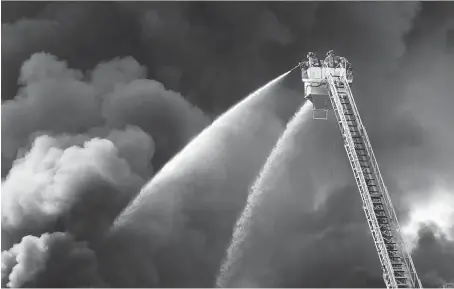  ?? DAX MELMER ?? Acrid clouds of smoke darkened the sky for hours as firefighte­rs battled a raging fire at a warehouse on Argyle Road. Police blocked roads while dozens of firefighte­rs battled the relentless flames, and paramedics were at the ready as the smoky haze made it hard for people to breathe.