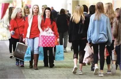  ?? STAFF PHOTO BY ERIN O. SMITH ?? From left, Samantha Robinson Freemon Taylor Robinson, 16, and Ralee Robinson, 17, carry bags through Hamilton Place mall as they shop Friday. They have gone Black Friday shopping every year since Taylor and Ralee were about 5 years old.