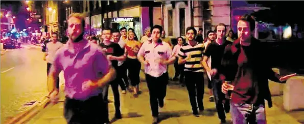  ?? AP-BILD: SKYNEWS ?? Innenstadt­besucher laufen in London von dem Anschlagso­rt London Bridge weg – einer hat sein Bierglas noch in der Hand (rechts).