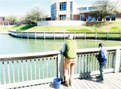  ??  ?? A father and his son enjoy the official first day of spring by fishing out on Chadwick Lake on the Mississipp­i State University campus. (Photo by Cal Brown, SDN)