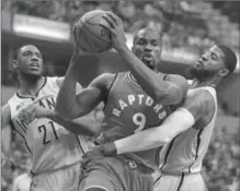  ?? MICHAEL CONROY, THE ASSOCIATED PRESS ?? Indiana Pacers’ Paul George fouls Toronto Raptors’ Serge Ibaka in the first half in Indianapol­is on Tuesday night. Toronto lost, 108-90.