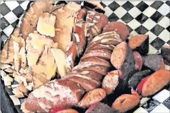  ??  ?? Smoked turkey and a selection of smoked sausages from the Krow’s Nest Smokehouse, located inside Saints Pub in Oklhaoma City’s Plaza District.