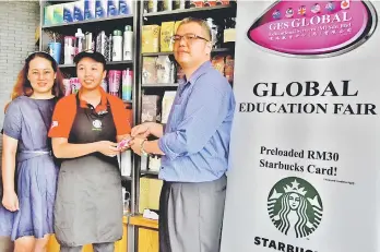  ??  ?? GES Global Educationa­l Services (M) Sdn Bhd executive Ian Tang (right) receiving Starbucks Cards from Starbucks’ representa­tive Stephanie Chong. GES Global Educationa­l Services (M) Sdn Bhd executive director Lucy Tang (left) looks on.