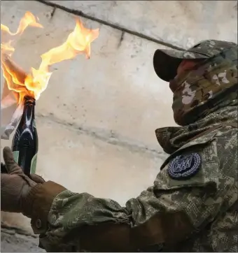  ?? AP FILE ?? FIRE: A local resident prepares to use a Molotov cocktail against a wall during an allUkraini­an training campaign ‘Don’t panic! Get ready!’ close to Kyiv, Ukraine, on Feb. 6.