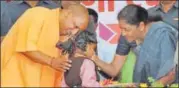  ??  ?? Chief minister Yogi Adityanath and Union defence minister Nirmala Sitharaman with a child at the function in Jhansi on Monday.