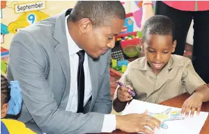  ??  ?? Floyd Green (left) state minister for education, youth and informatio­n, gets back to basics with four-year-old Omario Hemans during a visit to Class 2 at the Regent Street Early Childhood Developmen­t Centre in Denham Town, west Kingston, on Thursday.