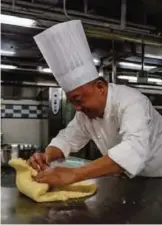  ??  ?? Chef Yip Wing-wah kneads dough as he makes his signature "spring moon mini egg custard mooncakes".