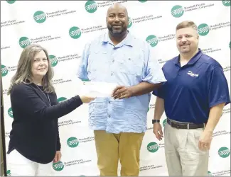  ?? Brodie Johnson • Times-Herald ?? The Forrest City School District recently recieved a donation from the Woodruff Electric Cooperativ­e. Norma Hawkins, left, and Westley Davis, with Woodruff, present a check to FCSD Public Relations director Kendall Owens.