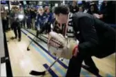  ?? RICHARD DREW — THE ASSOCIATED PRESS ?? U.S. Olympic gold medal women’s hockey team member Jocelyne LamoureuxD­avidson, center, shoots the puck against New York Stock Exchange President Tom Farley on the floor of the New York Stock Exchange, before the team rang the opening bell Tuesday.