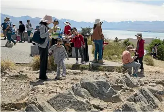  ?? BEJON HASWELL/STUFF ?? Tourists take in the view of Lake Tekapo from the summit of Mt John last week. Now there is a big dent in accommodat­ion bookings because of the Chinese ban on travel because of the coronaviru­s outbreak.