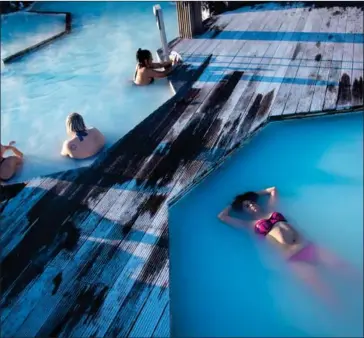  ?? THE WASHINGTON POST ?? Visitors to Grindavik, Iceland, enjoy a soak at the popular Blue Lagoon geothermal spa.