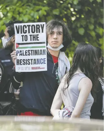  ?? ELIJAH NOUVELAGE / AFP VIA GETTY IMAGES ?? A protester holds up a sign as students demonstrat­e at Emory University in Atlanta, Ga., Thursday.