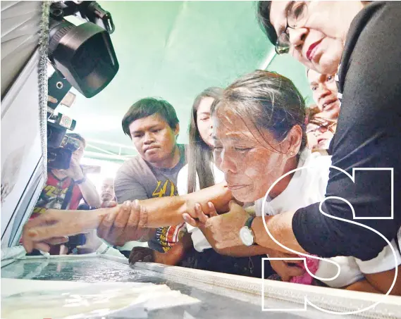  ?? SUNSTAR FOTO / ALAN TANGCAWAN ?? Lourdes Pardillo had to be restrained while she said her last goodbye to her daughter, 16-year-old Christine Lee Silawan, whose dead body was discovered last March 11. Silawan was laid to rest Saturday, March 23. FAREWELL.