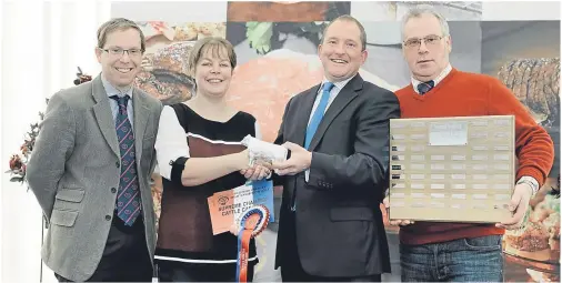  ??  ?? MEAT THE WINNER: Stephanie Ewart of S. Ewart & Sons is presented with her Silver Steer by Steve McLean, head of M&S Agricultur­e. Far left is Tom Slay, also of M&S, and far right Wilson Peters, Monzie, Crieff, who has donated a new trophy for the class