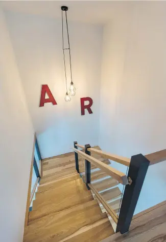  ??  ?? Hickory stairs lead to the second floor bedrooms and office. The funky letters were salvaged from Cassidy’s late father’s office. Allan Roy Cassidy was a Victoria architect. The letters were part of the sign outside the office and just so happened to...