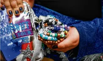  ?? ERIN CLARK/GLOBE STAFF ?? Emily Berry, riding the commuter train to Gillette Stadium for one of Taylor Swift’s shows last May, displays some of the friendship bracelets she made. Swifties can swap bracelets at an April 19 listening party and craft night hosted by Time Out Market.