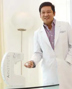  ?? Photos ERNIE PENAREDOND­O ?? A Institute head of hair restoratio­n Jose “Dr. Third” Crisanto III, with the Lotus Hair Restoratio­n System — the one and only in the country — which delivers a non-invasive, 30-minute treatment that involves autologous micro-grafting, injections and a laser cap to use at home.