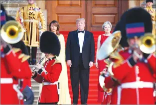  ?? AP PHOTO ?? Britain’s Prime Minister Theresa May, right, stands with U..S. President Donald Trump, centre, and U.S. first lady Melania Trump on the steps of the Great Court as the bands of the Scots, Irish and Welsh Guards perform a ceremonial welcome, as they...