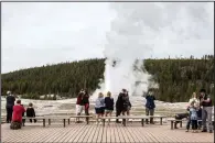  ?? (AP/Jackson Hole News & Guide/Ryan Dorgan) ?? Visitors at Yellowston­e National Park in Wyoming watch last month as Old Faithful erupts on the day the park partially reopened after a two-month shutdown.