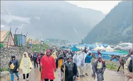  ?? ANI ?? Pilgrims on their way back to the base camp after the Amarnath Yatra was temporaril­y suspended due to bad weather on Tuesday.
