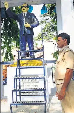  ?? HT PHOTO ?? A police constable deployed near an Ambedkar statue in Lakhimpur Kheri district. Senior police officials said the measures were taken to avoid any law and order situation due to statue desecratio­n. Ambedkar followers supported the efforts of the...