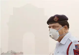  ??  ?? An Indian policeman wearing a protection mask as he works near India Gate amid heavy smog in New Delhi on Thursday. (AFP)