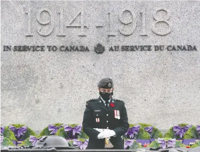  ?? TONY CALDWELL / POSTMEDIA NEWS ?? A Canadian soldier stands sentry at the Tomb of the Unknown Soldier, part of the National War Memorial,
Wednesday in Ottawa. By the afternoon, there was a pile of red poppies starting to cover the tomb.