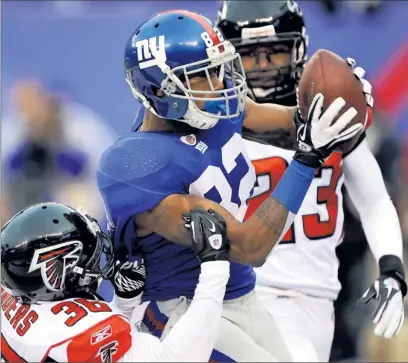  ?? By Steve Olijarczyk, USA TODAY ?? Catching momentum: Giants wide receiver Mario Manningham pulls down a 27-yard touchdown pass Sunday in front of Falcons safety James Sanders. Manningham posted four receptions for 68 yards in the Giants’ 24-2 wild-card round victory.