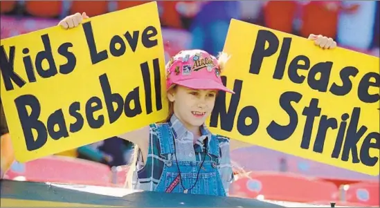  ?? Eric Risberg Associated Press ?? ERIN STATES, 10, of Tracy, Calif., holds signs during batting practice in Oakland a day before the 1994 strike. She never felt the same way about baseball after that. D7