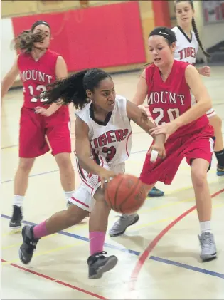  ?? Photo by Ernest A. Brown ?? Tolman's Destiny Moore (3) drives past Mount's Emily D'Abrosca (12) and Shea Kelliher (20) during first-half action Tuesday night.