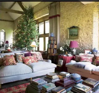  ??  ?? This page, clockwise fromtop Plump sofas and copious cushions give the sitting room – which is an extraordin­ary 35ft high – a comfortabl­e feel. The circular bookcase is Georgian; the rear exterior of the converted barn; Sue Jones at home with Max