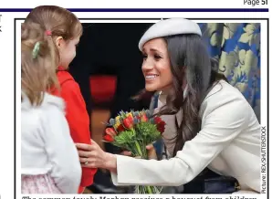  ??  ?? The common touch: Meghan receives a bouquet from children